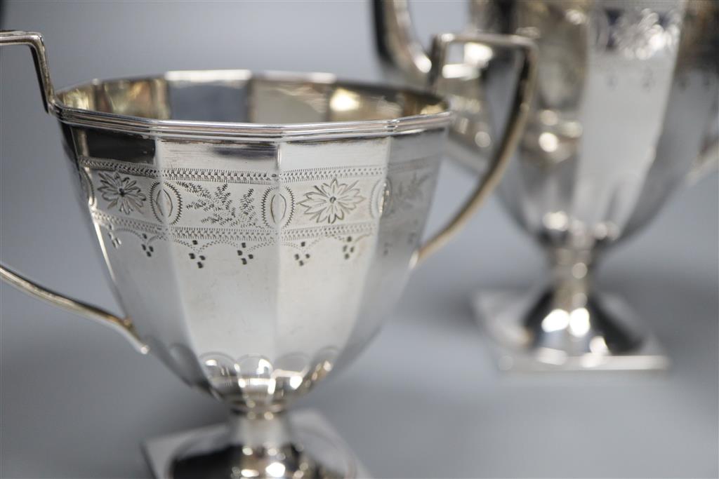 An Edwardian engraved silver three piece pedestal coffee set by James Deakin & Sons, Sheffield, 1904,